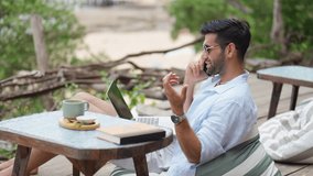 Businessman remote working corporate business on laptop computer and speaking on mobile phone at beach cafe. Caucasian man enjoy outdoor lifestyle travel at the sea on summer beach holiday vacation. - Powered by Shutterstock - Get 15% off with code: PIKWIZARD15