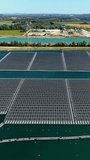 Solar farm on water with wind turbines in countryside, vertical video. - Powered by Shutterstock - Get 15% off with code: PIKWIZARD15