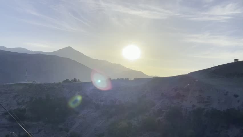 Kashmir Pakistan mountain - the rising sun break through the clouds and clouds. The last rays of the sunset hit the tree crowns.