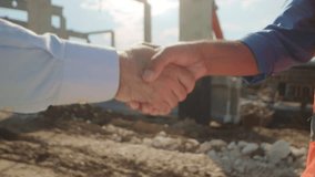 Close-up footage of shaking hands of builder and businessman in front of construction site. Blurred background. Sunny day. Construction agreement. Outdoors - Powered by Shutterstock - Get 15% off with code: PIKWIZARD15