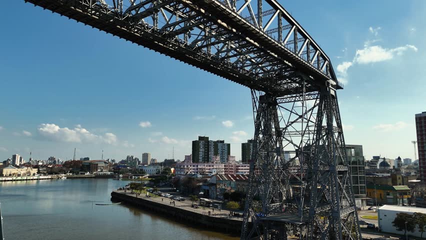 La Boca ferry bridge on the riachuelo and panoramic view of Buenos Aires, Argentina. Aerial camera rises from the bridge and shows the city