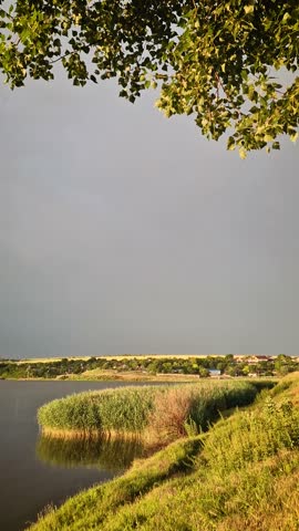 Massive storm formation with lightnings in the sky above a countryside landscape. Thunderstorm after heavy rain. Extreme summer weather with dramatic flashes strikes