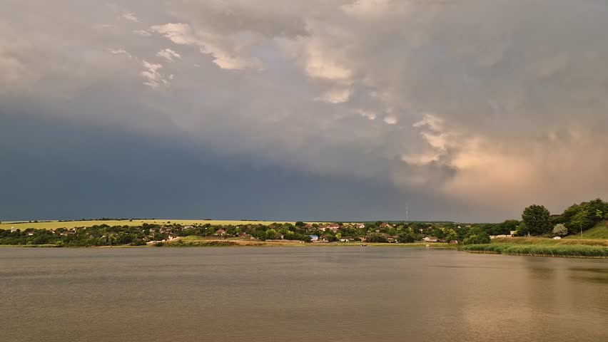Massive storm formation with lightnings in the sky above a countryside landscape. Thunderstorm after heavy rain. Extreme summer weather with dramatic flashes strikes
