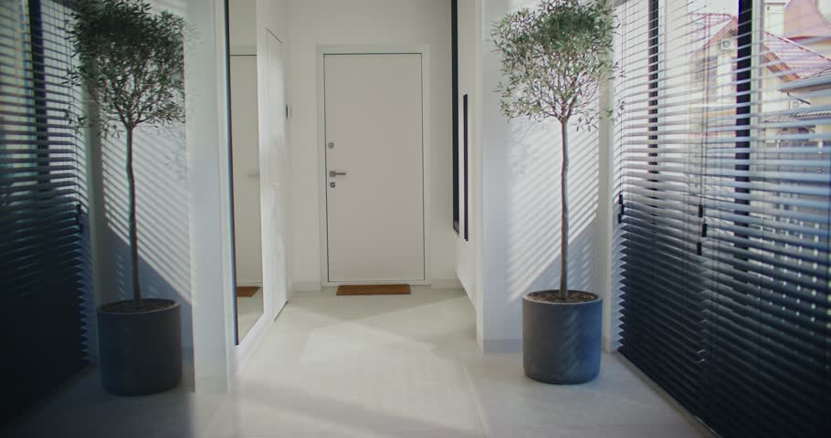 Camera view of military man in camouflage arriving home. Happy woman with joy meeting her hero from military service or war. Couple happily hugging together in corridor at home. Family reunion.