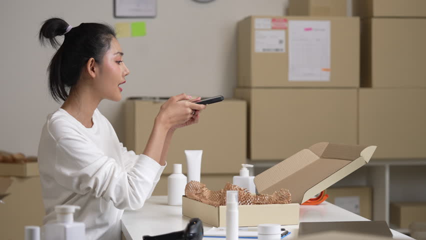 Asian woman online seller packing package post shipping box preparing delivery parcel on table. Ecommerce dropshipping shipment service concept.
