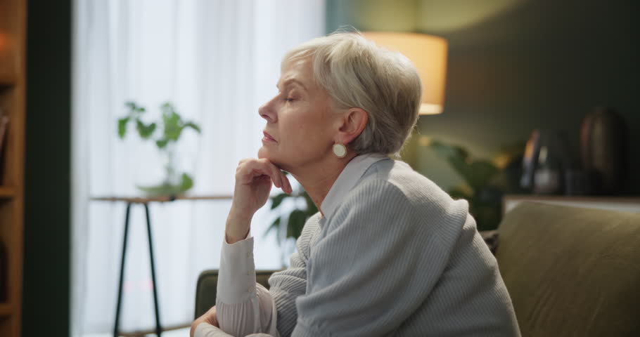 Senior, woman and thinking about alzheimer diagnosis and assisted living for medical support. Mature, female person and idea or vision on sofa for healthcare help at retirement home for wellness