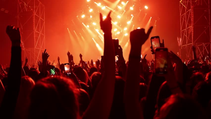 Euphoric people dancing on the dance floor during a concert at a festival.