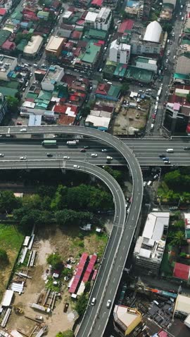Metro Manila Skyway with vehicles and residential area, top view. Makati, Philippines. Vertical view.