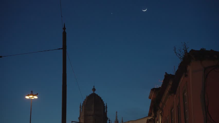 Night in Belém: A crescent moon shines above the Jerónimos Monastery.