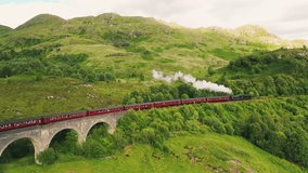 Aerial View of the famous Jacobite Steam Train leaving the Glenfinnan Viaduct Railway Bridge in the Scottish Highlands, Scotland, United Kingdom - Powered by Shutterstock - Get 15% off with code: PIKWIZARD15