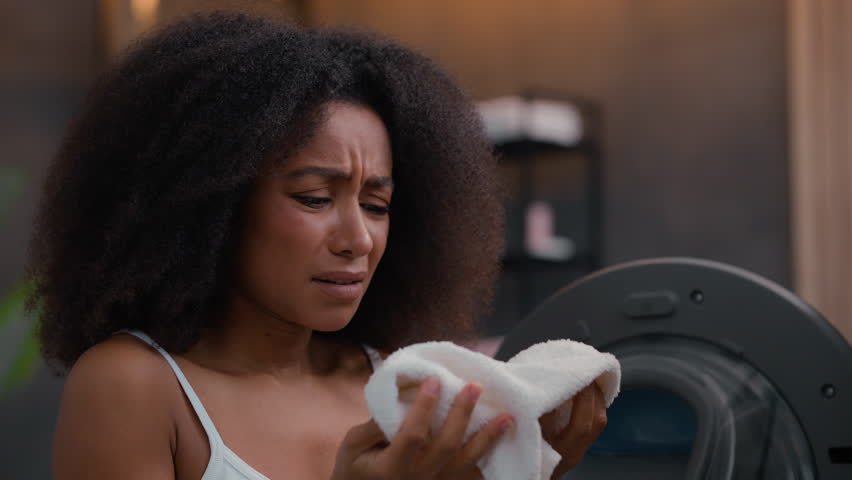 African American woman girl female sad failure frustrated frown lady housework housewife open door broken washing machine laundry bad terrible smelling sniff odor smell aroma white towel gel mistake