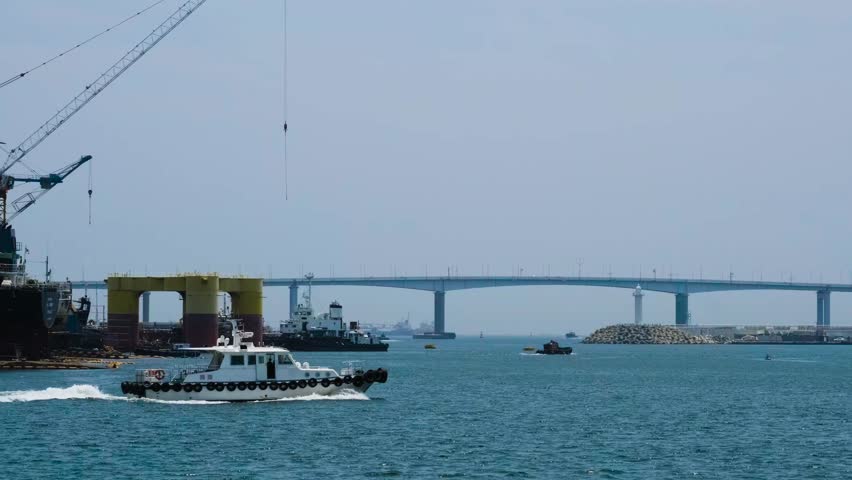 4k - A small yacht is heading somewhere across the sea in Busan and the camera follows the boat. Blue sea cool feeling