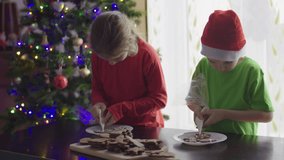 Children Decorating Gingerbread Christmas Cookie. Brother And Sister Making Christmas Cookies Together In Domestic Kitchen, They Having Fun And Decoration Sweet Cookies. Merry Christmas Happy Holidays - Powered by Shutterstock - Get 15% off with code: PIKWIZARD15