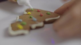 Child Garnishing White Icing Homemade Gingerbread, Festive Illuminate Decor. Close up Children Decorating Gingerbread Christmas Cookie. Kids Making Christmas Cookies Together In Home. Merry Christmas. - Powered by Shutterstock - Get 15% off with code: PIKWIZARD15
