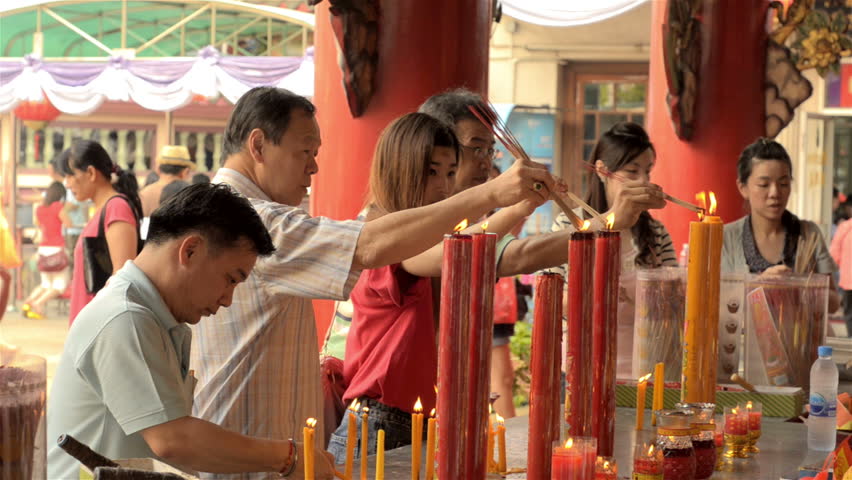BANGKOK, THAILAND  - FEBRUARY 9, 2013: Thai people lighting candles  at a shrine
