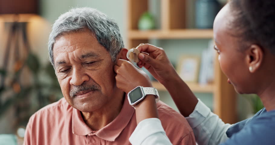 Nurse, patient with disability and hearing aid on ear for medical support, wellness and innovation. People, healthcare worker and deaf person with audiology implant, service or help for sound waves