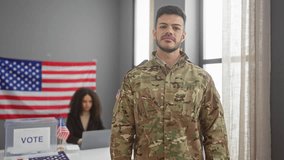 A confident soldier in camouflage with folded arms stands in a voting station, while a focused woman sits behind a laptop, both in a room with an american flag. - Powered by Shutterstock - Get 15% off with code: PIKWIZARD15