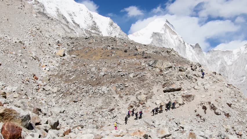 .Group of trekkers with guides trek final push to EBC viewpoint in Sagarmatha national park. EBC trekking. Everest base camp trekking in fall, autumn in sunny weather.