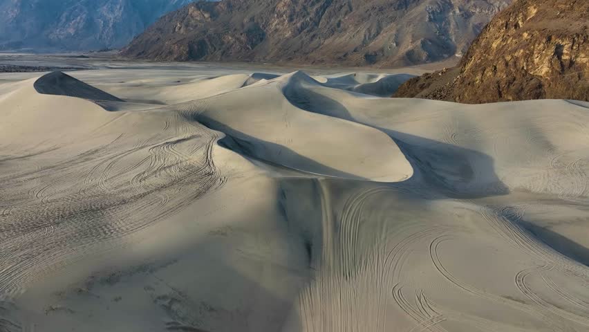 Sand dunes in Sarfaranga Cold Desert with tire tracks, Skardu Valley - aerial flyover