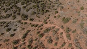 Aerial Flight in the american desert. Red, brown arid soil, wild land. Drone cinematic shot of a desert landscape, dry semi-arid american region. Sand, rocks and desert shrubs. Sedona Arizona desert - Powered by Shutterstock - Get 15% off with code: PIKWIZARD15