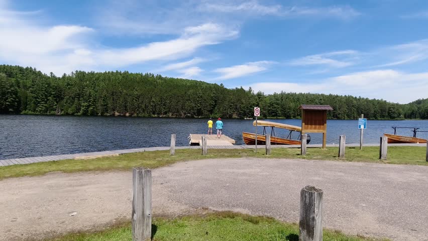 Two men fishing on the dock by lake in Algonquin Park Canada