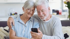 Happy mature family, wife and husband using phone together at home, smiling middle aged man and woman sitting on couch, using mobile device apps, watching video in social network, surfing internet
 - Powered by Shutterstock - Get 15% off with code: PIKWIZARD15