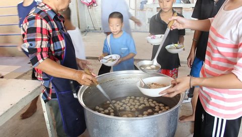ANG THONG, THAILAND - CIRCA DECEMBER 2012: Orphans in Wat Tarn Jet Cho Temple are getting  free lunch from Philanthropists.