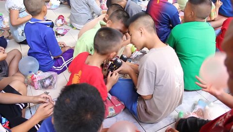 ANG THONG, THAILAND - CIRCA DECEMBER 2012: Orphans in Wat Tarn Jet Cho Temple are happy to get  special gifts and playing together.