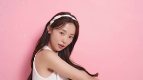 Video of a young Asian woman's catchy beauty image shot on a pink background - Powered by Shutterstock - Get 15% off with code: PIKWIZARD15
