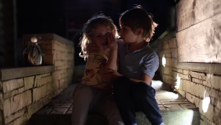 Happy children oudoors at night, having fun laughing and enjoying warm spring night	