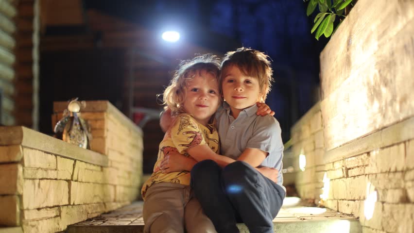 Happy children oudoors at night, having fun laughing and enjoying warm spring night	