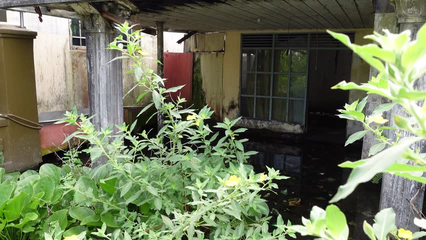 The front view of an empty, abandoned house looks flooded