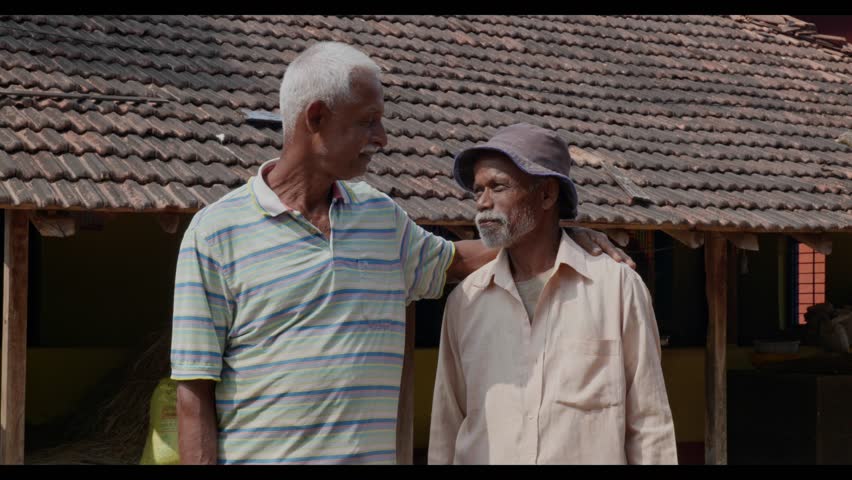 Dapoli, Maharashtra, India - December 18th 2023- two Indian old men are standing together keeping hand on the shoulder and smiling into the camera.