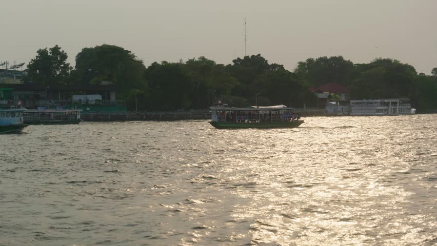 The view of a harbor with passing boats.
