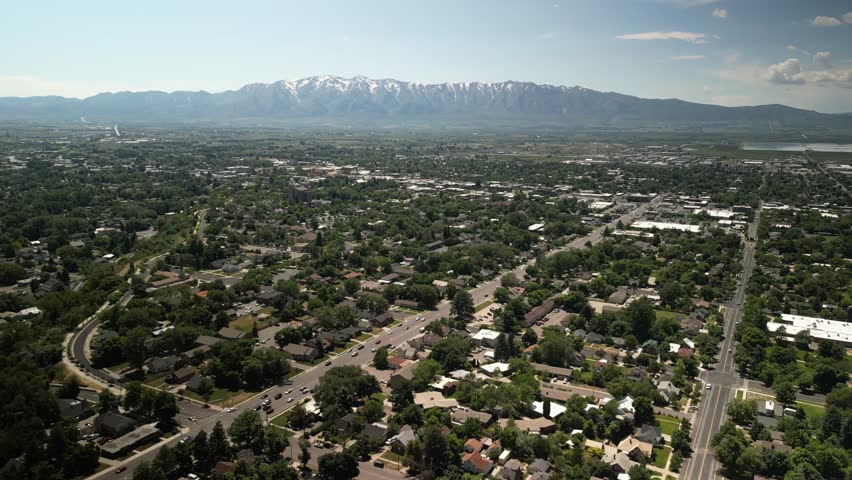 High aerial above suburbs of Logan Utah in spring