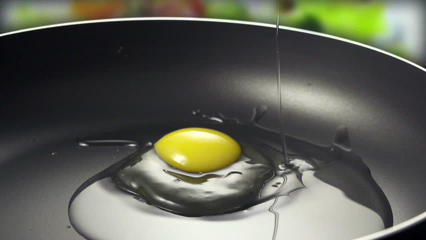 Raw egg in frying pan on colorfull background