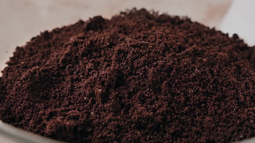 A slow-motion closeup of milk being Poured to blended chocolate cookies in a glass bowl