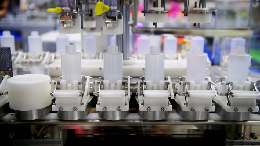 White plastic bottles in a conveyor belt on a high quality automatic vertical filling machine. in the factory production line