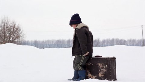 boy with a suitcase in winter
