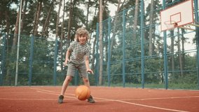 Happy positive cute teen boy bouncing ball practicing basketball moves outdoor on court. Caucasian little cheerful child playing basketball. Dribble moves. Fun. Leisure activity. Childhood concept - Powered by Shutterstock - Get 15% off with code: PIKWIZARD15