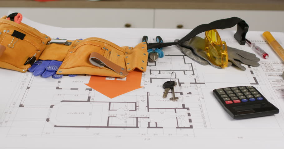 Builder puts tool belt on architectural drawing with supplies closeup. Constructor finishes work and leaves instruments in agency office