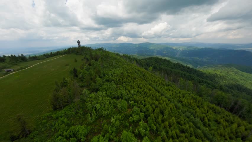 Majestic watchtower in middle of forest hill, aerial FPV view