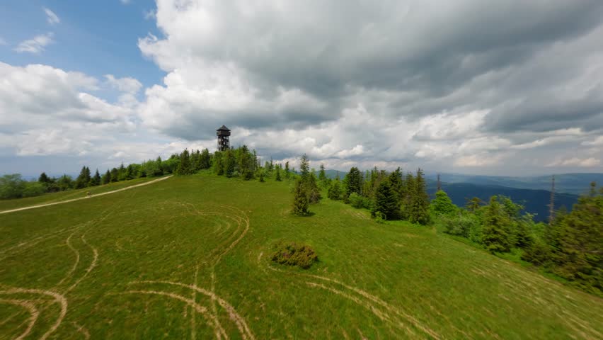 Cloudy sky and tall watchtower in Poland, aerial FPV view