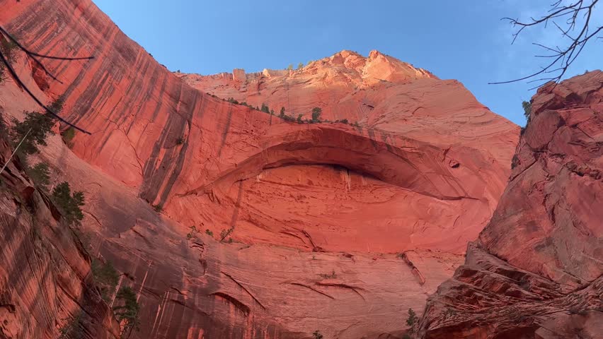 Tilt down shot of the massive Double Arch rock formation in Kolob Canyons, Zion National Park. A person stands at the bottom for scale - Taylor Creek, Utah, USA