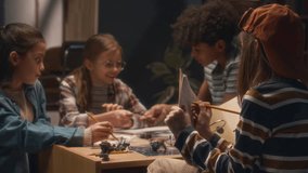 Back shot of boy writing down info about process of playing board game while his diverse friends discussing their character cards at home in evening - Powered by Shutterstock - Get 15% off with code: PIKWIZARD15
