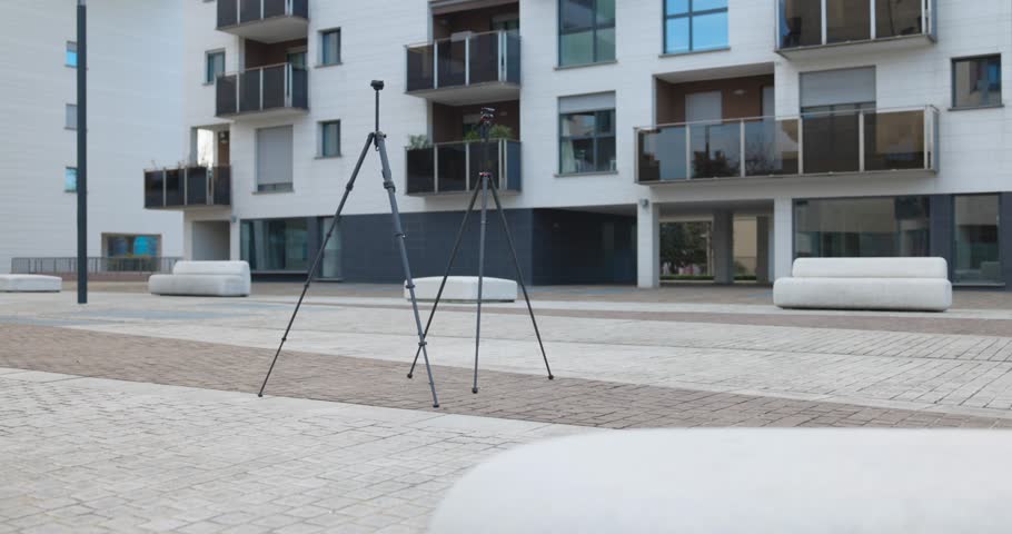Two lightweight travel tripods in front of apartment building, photography equipment