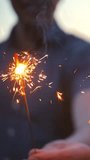 The couple dancing with firework sticks on an evening sunset background. Super slow motion. Close-up of fireworks and sparklers Blurred faces of young guy and girl. Vertical shot. - Powered by Shutterstock - Get 15% off with code: PIKWIZARD15