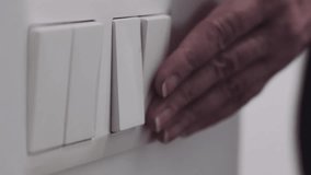 Finger switching on wall-mounted light switch. Power, energy and electricity consumption. - Powered by Shutterstock - Get 15% off with code: PIKWIZARD15