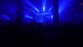 A dynamic club scene with an impressive blue laser light show. The energetic crowd dances and raises their hands, creating a vibrant and electrifying atmosphere. - Powered by Shutterstock - Get 15% off with code: PIKWIZARD15