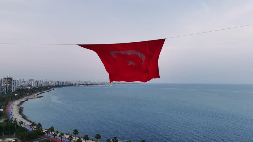 A close-up shot of the Turkish flag, showcasing the vibrant red color and the star and crescent symbol fluttering gracefully in the wind